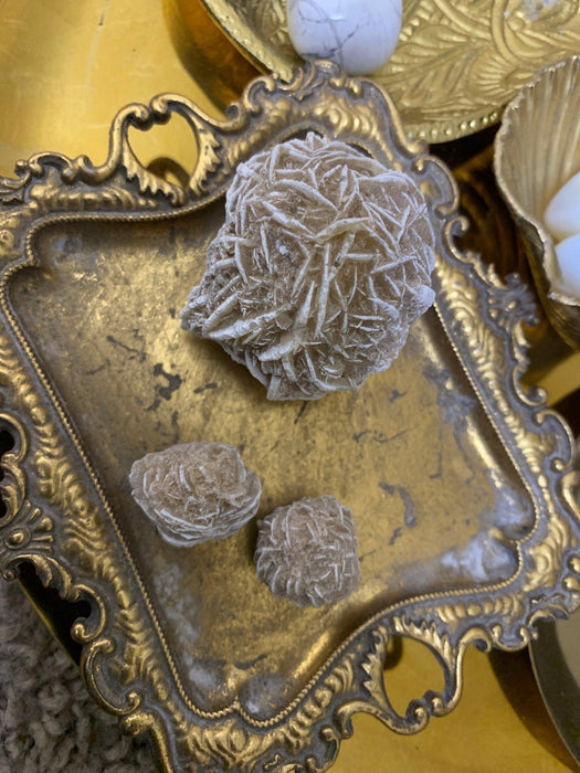 Delicate Desert Rose Selenite clusters on an ornate tray, each unique crystal promoting peace, clarity, and a high vibrational energy.
